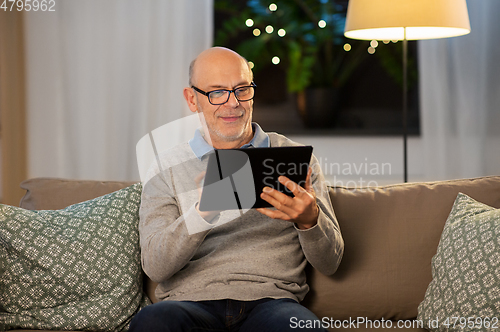 Image of happy senior man with tablet computer at home