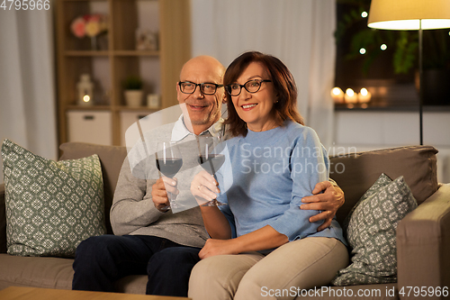 Image of happy senior couple with glasses of red wine