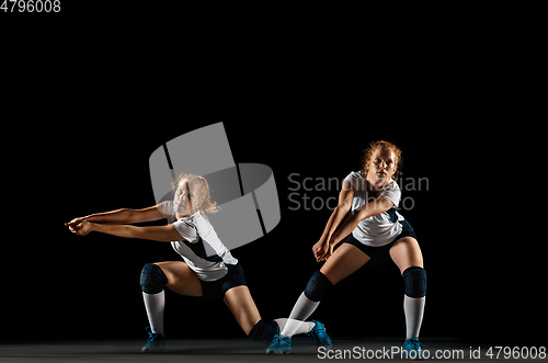 Image of Young female volleyball player isolated on black studio background