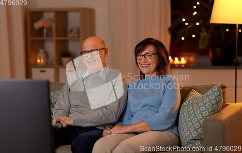 Image of happy senior couple watching tv at home