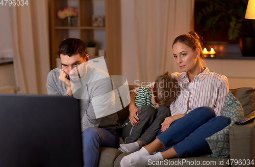 Image of family watching something boring on tv at night