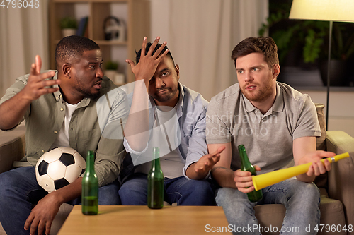 Image of sad male friends or soccer fans with beer at home