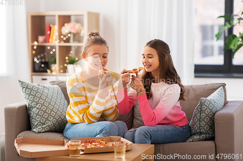 Image of happy teenage girls eating takeaway pizza at home