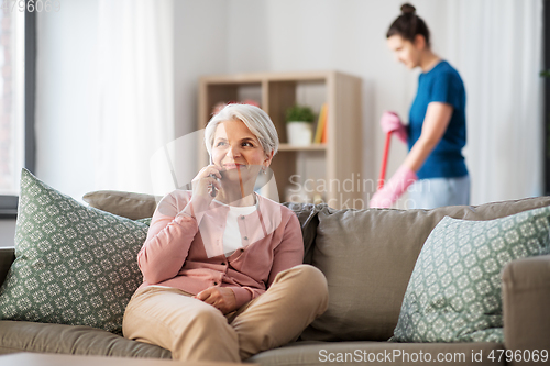 Image of happy senior woman calling on smartphone at home