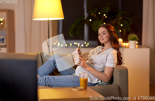 Image of pregnant woman watching tv and eating wok at home