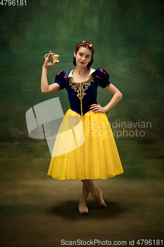 Image of Young ballet dancer as a Snow White with poisoned apple in forest