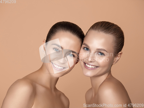 Image of Portrait of beautiful young women isolated on brown studio background