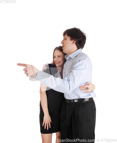 Image of Young couple standing, man is pointing