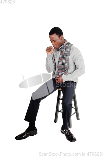 Image of Coughing young African man sitting on chair