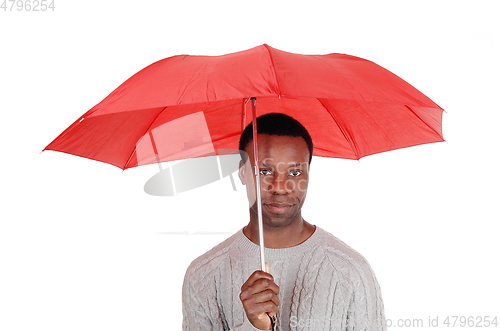 Image of Black man standing and holding a red umbrella