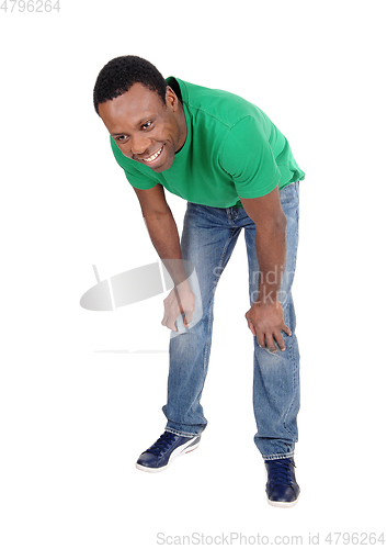 Image of Happy African man in jeans bending down