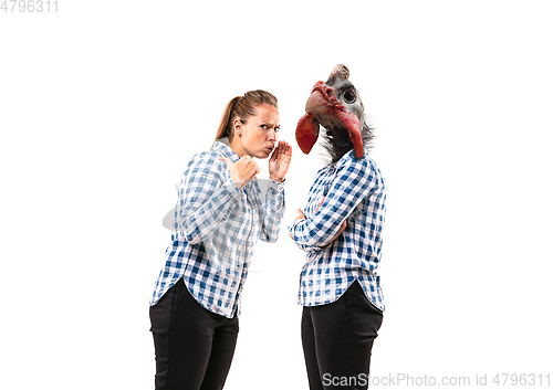 Image of Young handsome woman arguing with herself as a chicken on white studio background.