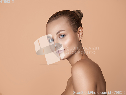 Image of Portrait of beautiful young woman isolated on brown studio background