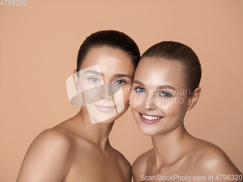 Image of Portrait of beautiful young women isolated on brown studio background