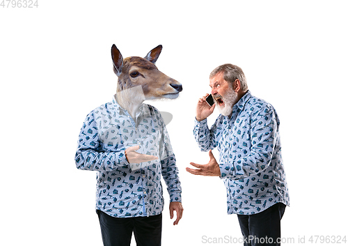 Image of Senior man arguing with himself as a deer on white studio background.
