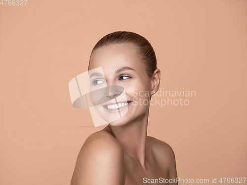 Image of Portrait of beautiful young woman isolated on brown studio background
