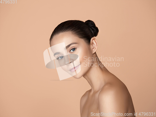 Image of Portrait of beautiful young woman isolated on brown studio background