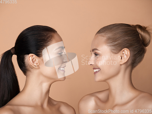 Image of Portrait of beautiful young women isolated on brown studio background