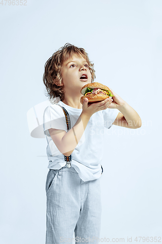 Image of Pretty young boy in casual clothes on white studio background