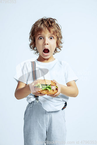 Image of Pretty young boy in casual clothes on white studio background