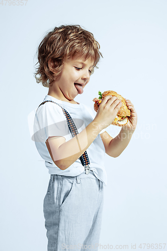 Image of Pretty young boy in casual clothes on white studio background