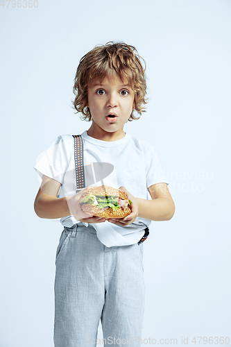 Image of Pretty young boy in casual clothes on white studio background