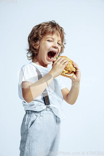 Image of Pretty young boy in casual clothes on white studio background