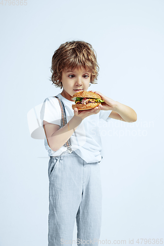 Image of Pretty young boy in casual clothes on white studio background