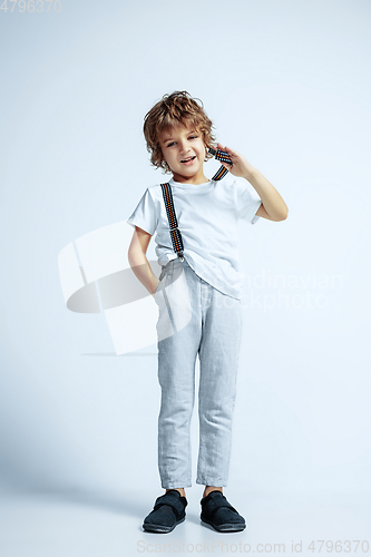 Image of Pretty young boy in casual clothes on white studio background