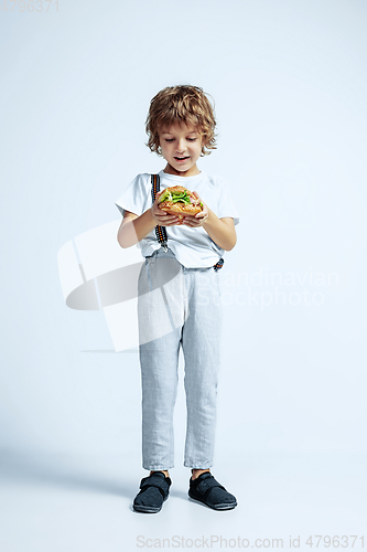 Image of Pretty young boy in casual clothes on white studio background