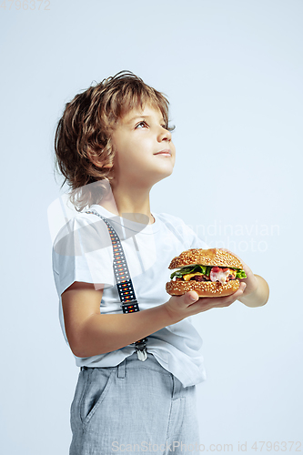 Image of Pretty young boy in casual clothes on white studio background