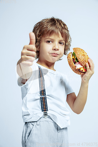 Image of Pretty young boy in casual clothes on white studio background