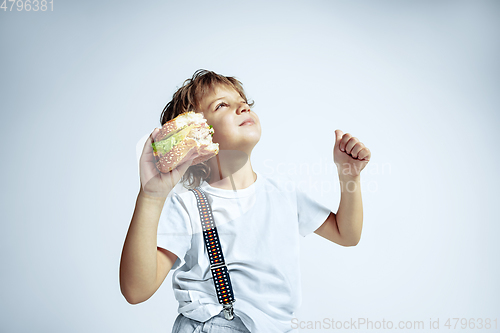 Image of Pretty young boy in casual clothes on white studio background