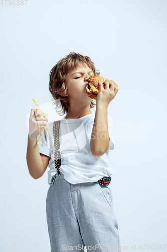 Image of Pretty young boy in casual clothes on white studio background