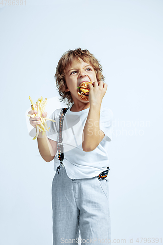 Image of Pretty young boy in casual clothes on white studio background