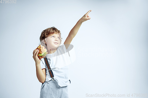 Image of Pretty young boy in casual clothes on white studio background