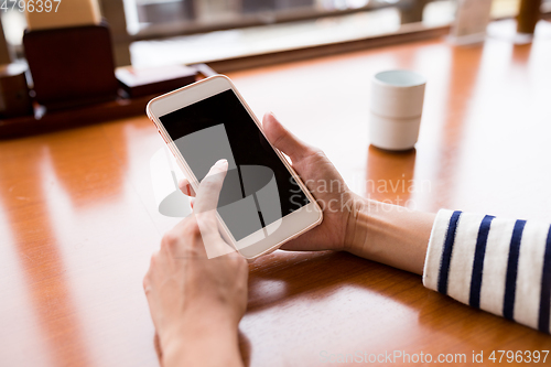 Image of Woman using cellphone at restaurant