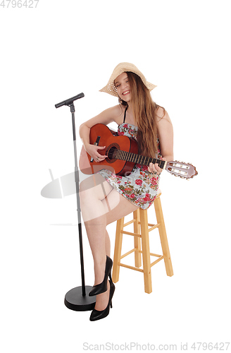 Image of Woman playing guitar and singing