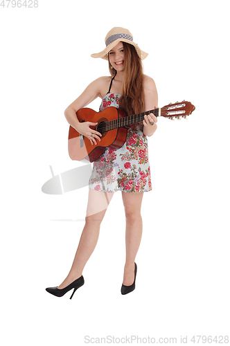 Image of Woman standing in a dress with her guitar