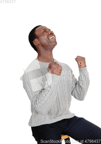 Image of Happy African man with fists looking up