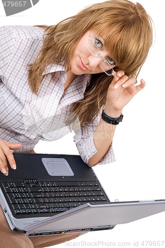 Image of The young woman in glasses sits with the laptop. Isolated