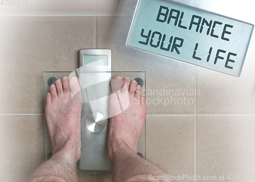 Image of Man\'s feet on weight scale - Balance your life