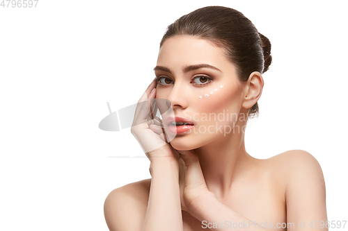 Image of girl applying moisturizing cream isolated on white