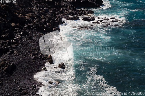 Image of beautiful view on ocean water and black lava sand