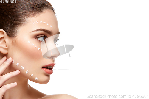 Image of girl applying foundation on face isolated on white