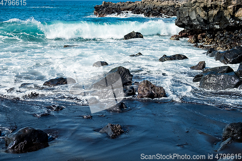 Image of beautiful view on ocean water and black lava sand