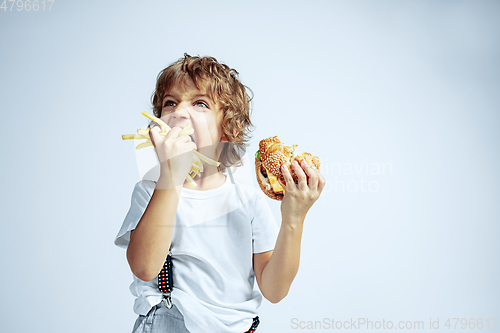 Image of Pretty young boy in casual clothes on white studio background