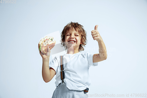 Image of Pretty young boy in casual clothes on white studio background