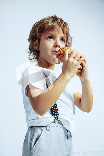 Image of Pretty young boy in casual clothes on white studio background