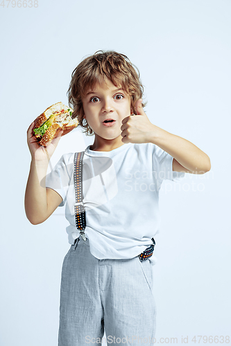 Image of Pretty young boy in casual clothes on white studio background